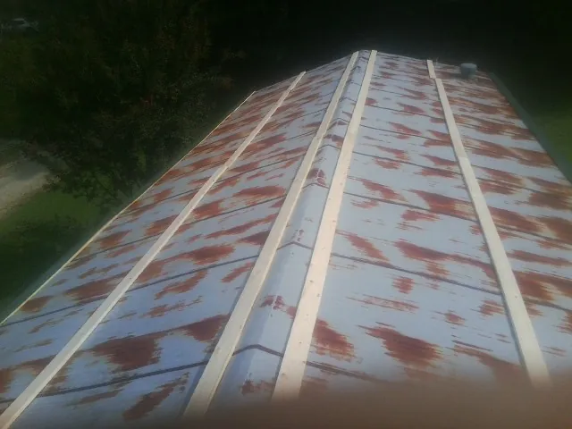 Rusted metal roof panels with new wood purlins before replacement — Storm Damage Roof Repair in Oakland by Roofing Brothers